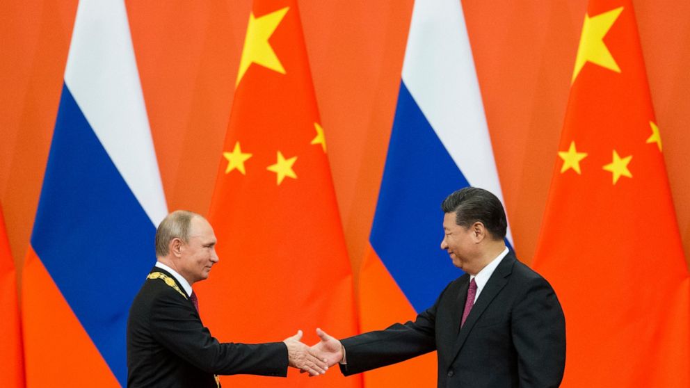 FILE - Chinese President Xi Jinping, right, and Russian President Vladimir Putin shake hands during an awarding ceremony at the Great Hall of the People in Beijing, China, on June 8, 2018. Xi is keeping the West guessing about whether Beijing will co