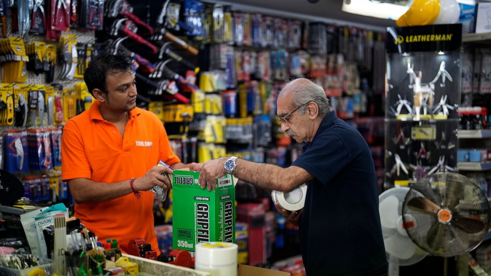 Store employees Ankur Patel, left, who was born in the state of Gujarat in India, and Martin Matio who is of Armenian ancestry and moved to the UK after living in California in the U.S., unload a stock delivery at a branch of the Tool Shop hardware s