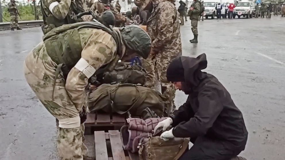 In this photo taken from video released by the Russian Defense Ministry on Thursday, May 19, 2022, shows Russian servicemen frisking Ukrainian servicemen after they leaved the besieged Azovstal steel plant in Mariupol, in territory under the governme