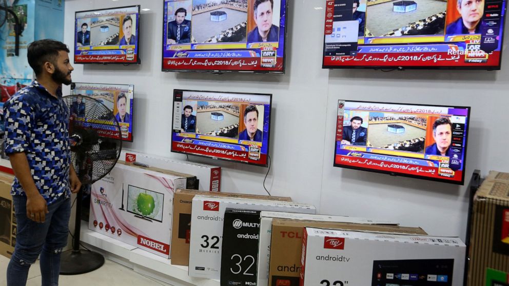 A Pakistan watches news channel flashing news regarding FATF decision, at a market in Karachi, Pakistan, Friday, June 17, 2022. An international watchdog said Friday it will keep Pakistan on a so-called "gray list" of countries that do not take full 