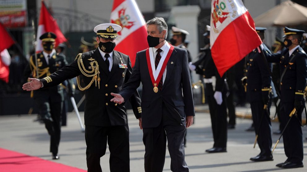 Francisco Sagasti is shown the way by his military escort as he arrives to be sworn-in as the new, interim president at Congress in Lima, Peru, Tuesday, Nov. 17, 2020. Sagasti's appointment marks a tumultuous week in which thousands took to the stree