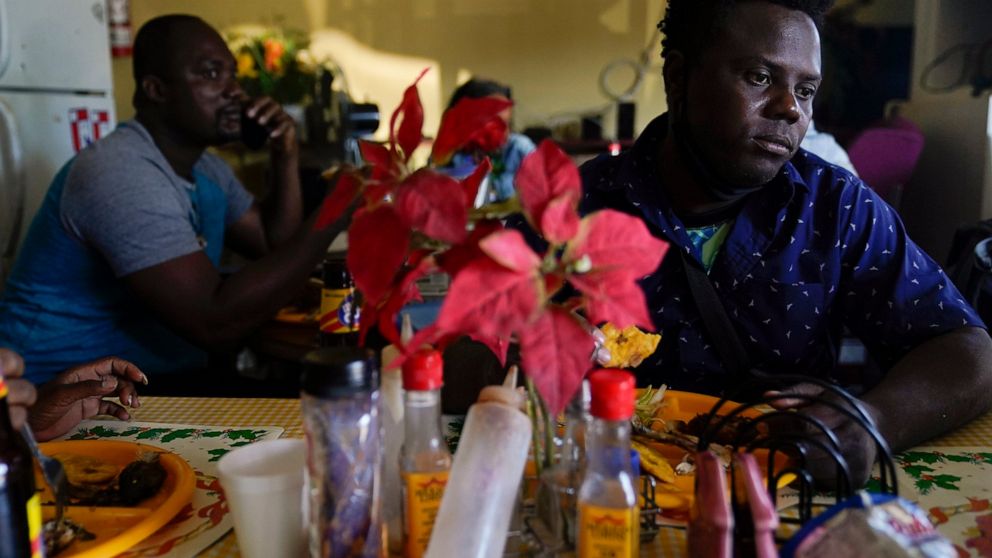 Robins Exile, of Haiti, eats at a Haitian restaurant, Monday, Sept. 20, 2021, in Tijuana, Mexico. Exile arrived to Tijuana the day before after changing his plans to head to the Texas border where thousands of Haitians have converged in recent days a