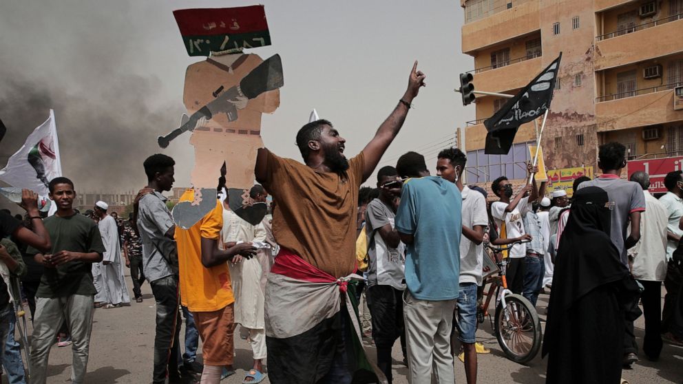 Sudanese protesters commemorate the third anniversary of a deadly crackdown carried out by security forces on protesters during a sit-in outside the army headquarters, in Khartoum, Sudan, Friday, June 3, 2022. Talks aiming at ending Sudan’s ongoing p