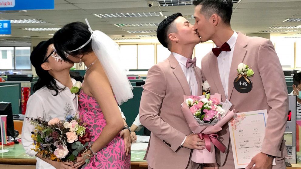 Two same-sex couples seal their legal marriage with a kiss at the registration office in Xingyi District in Taipei, Taiwan, Friday, May 24, 2019. Hundreds of same-sex couples in Taiwan are rushing to the household registration office on the first day