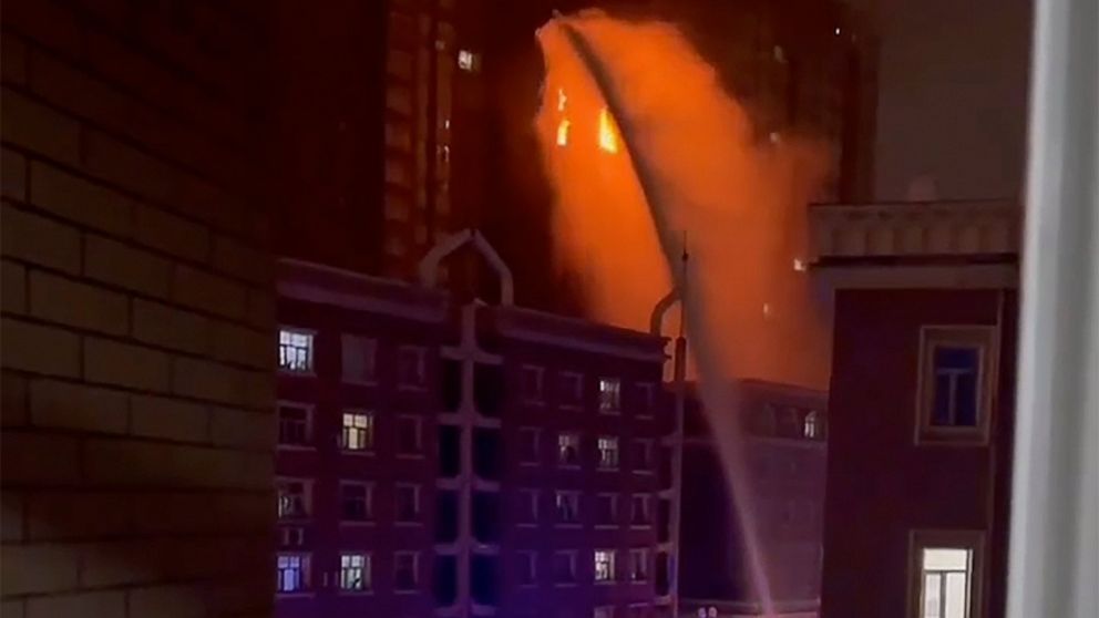 In this image taken from video, firefighters spray water on a fire at a residential building in Urumqi in western China's Xinjiang Uyghur Autonomous Region, Thursday, Nov. 24, 2022. A fire in an apartment building in northwestern China's Xinjiang reg