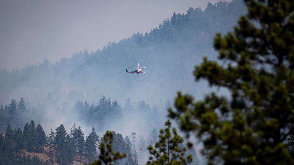 A helicopter pilot prepares to drop water on a wildfire burning in Lytton, B.C., on Friday, July 2, 2021. Officials on Friday hunted for any missing residents of a British Columbia town destroyed by wildfire as Canadian Prime Minister Justin Trudeau 