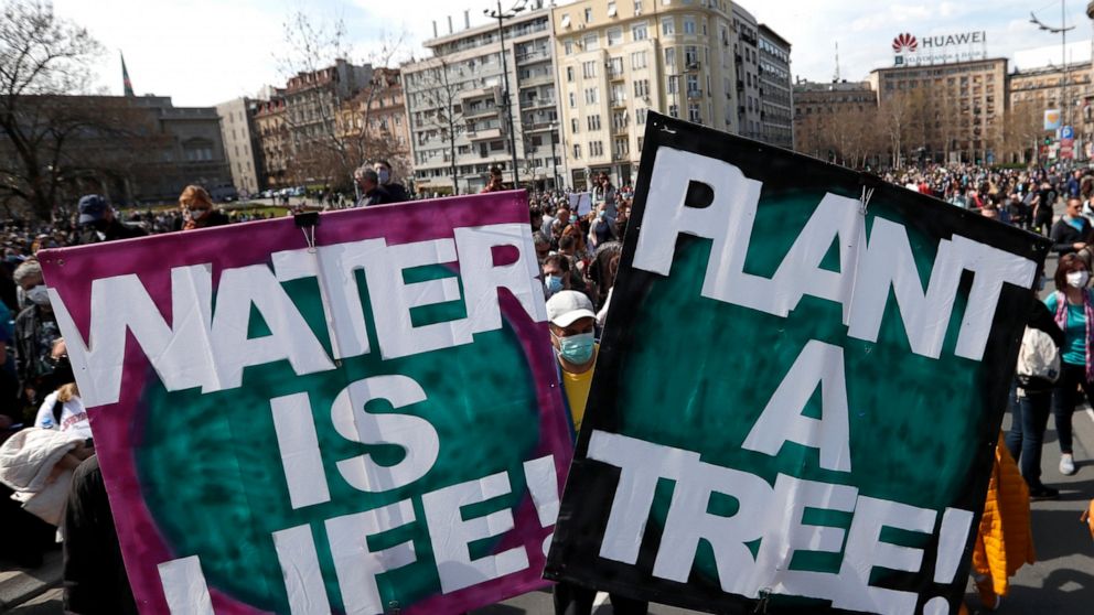 People hold banners during a protest in front of the Serbian Parliament building in Belgrade, Serbia, Saturday, April 10, 2021. Environmental activists are protesting against worsening environmental situation in Serbia. (AP Photo/Darko Vojinovic)