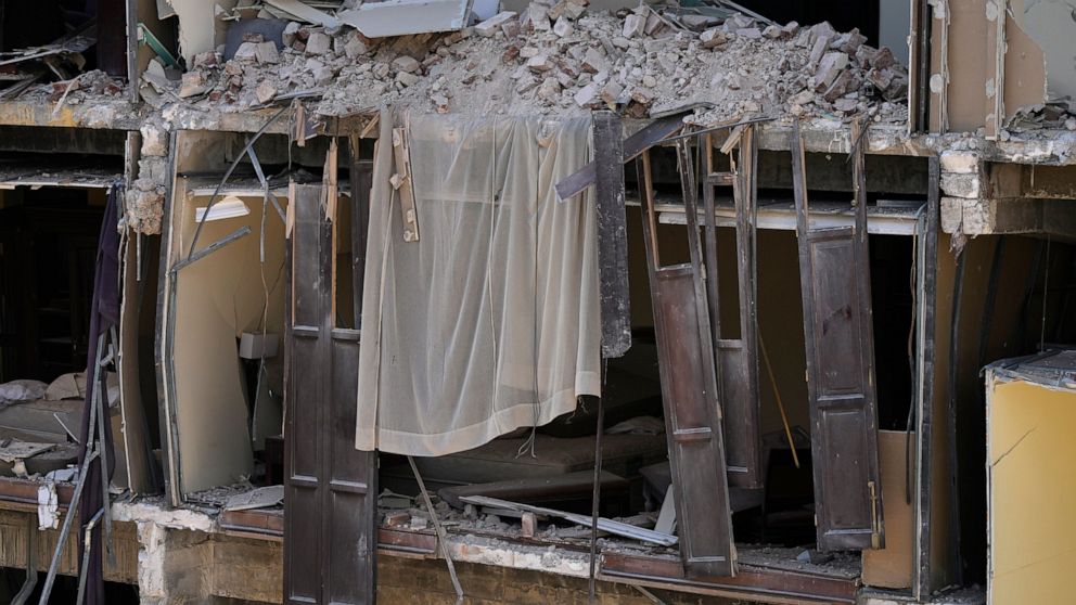 A sheer curtain covered in debris hangs from the exposed facade of the five-star Hotel Saratoga destroyed by a Friday deadly explosion, in Havana, Cuba, Saturday, May 7, 2022. (AP Photo/Ramon Espinosa)