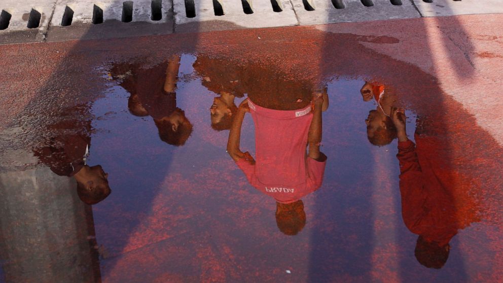 FILE-In this Aug. 26, 2012 file photo, members of Nepal's LGBT community are reflected on a water logged track as they participate in a physical training at the Dasarath stadium in Katmandu, Nepal. Nepal's upcoming national census will for the first 
