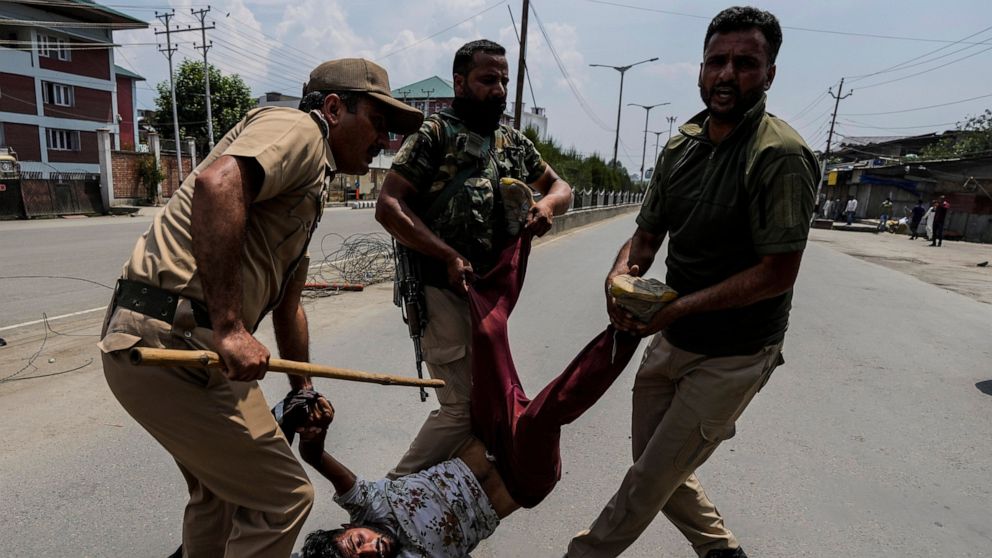 Indian policemen detain a Kashmiri Shiite Muslim for participating in a religious procession during restrictions in Srinagar, Indian controlled Kashmir, Sunday, Aug. 7, 2022. Authorities had imposed restrictions in parts of Srinagar, the region's mai