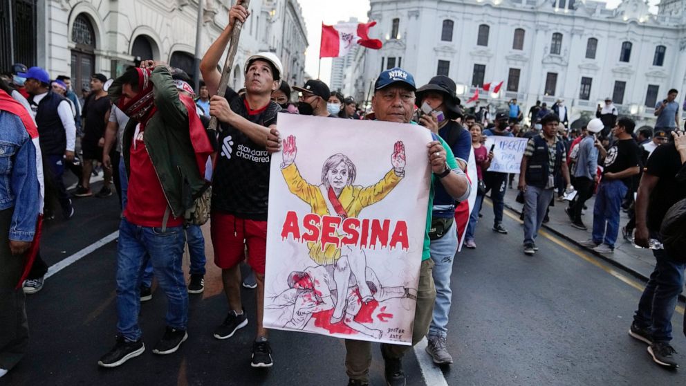Supporters of ousted President Pedro Castillo hold a poster depicting Peru's new president, Dina Boluarte, along with sign "Killer" during a protest in Lima, Peru, Monday, Dec. 12, 2022. Peru's Congress voted to remove Castillo from office Wednesday 