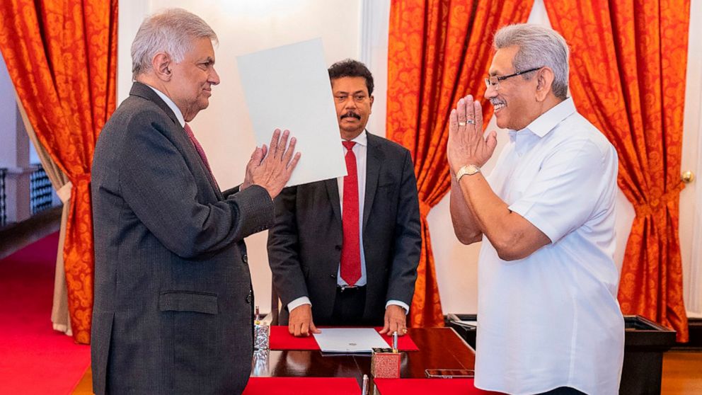 In this handout photograph provided by the Sri Lankan President's Office, President Gotabaya Rajapaksa, right, greets prime minister Ranil Wickremesinghe during the latter's oath taking ceremony as the new finance minister in Colombo, Sri Lanka, Wedn