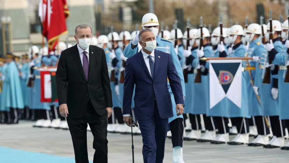 Turkey's President Recep Tayyip Erdogan, left, walks with Iraqi Prime Minister Mustafa al-Kadhimi, centre, as they review an honour guard during a welcome ceremony prior to their meeting at the Presidential Palace in Ankara, Turkey, Thursday, Dec. 17