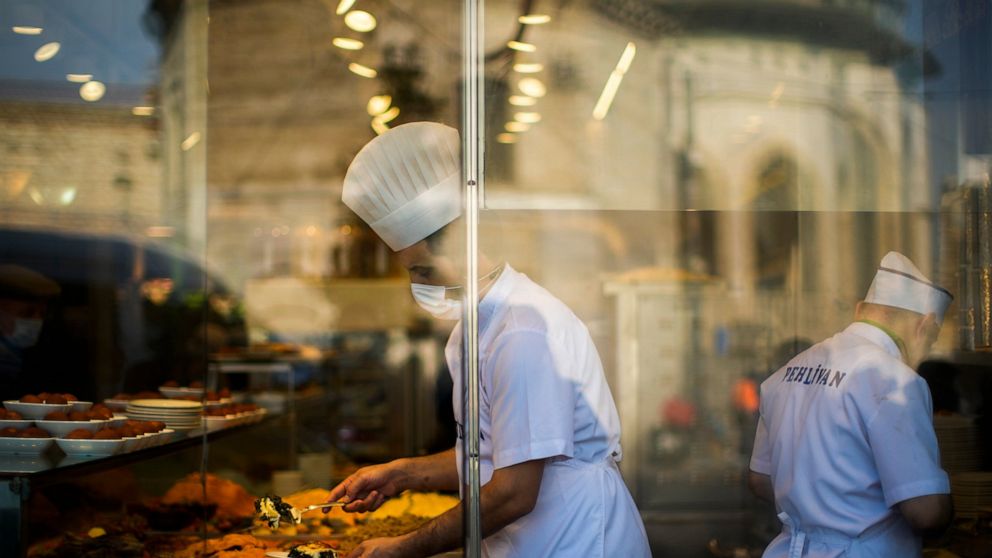 A chef serves meals to clients in a local 'lokantasi' or popular restaurant in Istanbul, Turkey, Monday, Jan. 3, 2022. Turkey's yearly inflation climbed by the fastest pace in 19 years, jumping to 36.08% in December, official data showed on Monday. (