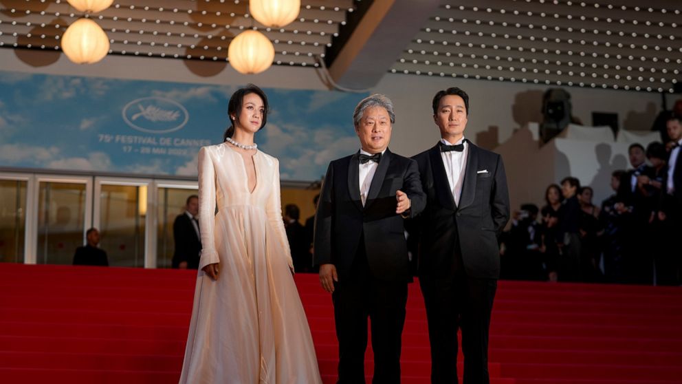 Tang Wei, from left, director Park Chan-wook, and Park Hae-il pose for photographers after departing the premiere of the film 'Decision to Leave' at the 75th international film festival, Cannes, southern France, Monday, May 23, 2022. (AP Photo/Petros