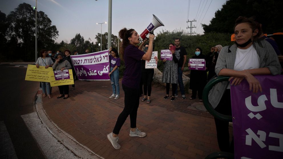 Protesters hold signs and chant slogans during a demonstration against violence near the house of Public Security Minister Omer Barlev in the central Israeli town of Kokhav Ya'ir, Saturday, Sept. 25, 2021. Arab citizens of Israel are seeking to raise