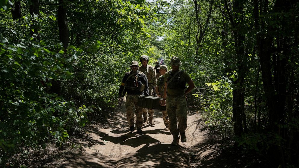 Ukrainian servicemen carry ammunition during training in Kharkiv region, Ukraine, Tuesday, July 19, 2022. (AP Photo/Evgeniy Maloletka)