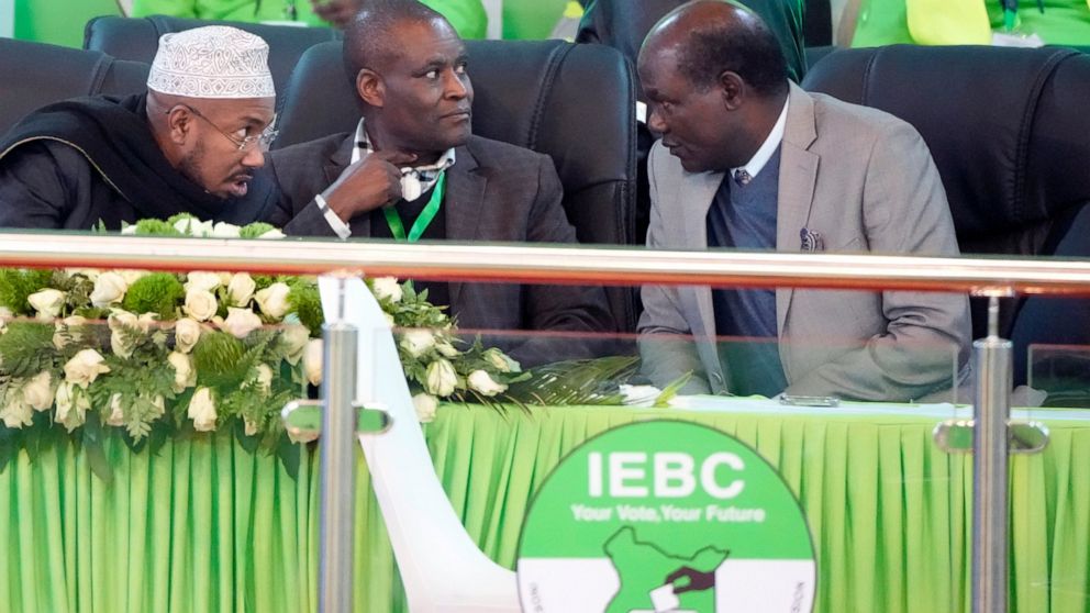 Electoral Commission (IEBC) Chairman, Wafula Chebukati, right, chats with IEBC commissioners, at the National Tallying Centre in Bomas of Kenya, Nairobi, Kenya, Friday, Aug. 12, 2022. Kenyans are waiting for the results of a close presidential electi
