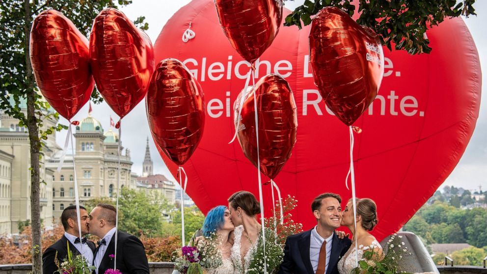 Operation Libero stages a photo opportunity of a marriage with three different couples, in Bern, Sunday, Sept. 26, 2021. Switzerland’s executive body says same-sex couples can get married starting July 1 next year. The Federal Council officially set 