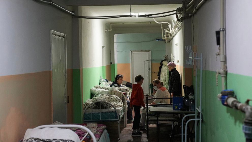 Women and their children sit in the basement of a maternity hospital converted into a medical ward and used as a bomb shelter in Mariupol, Ukraine, Monday, Feb. 28, 2022. In makeshift shelters and underground railway platforms across Ukraine, familie