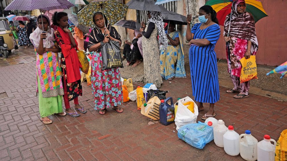 Women wait in a queue to buy kerosene in in Colombo, Sri Lanka, Saturday, June 11, 2022. Sri Lanka's economic crisis, the worst in its history, has completely recast the lives of the country's once galloping middle class. For many families that never