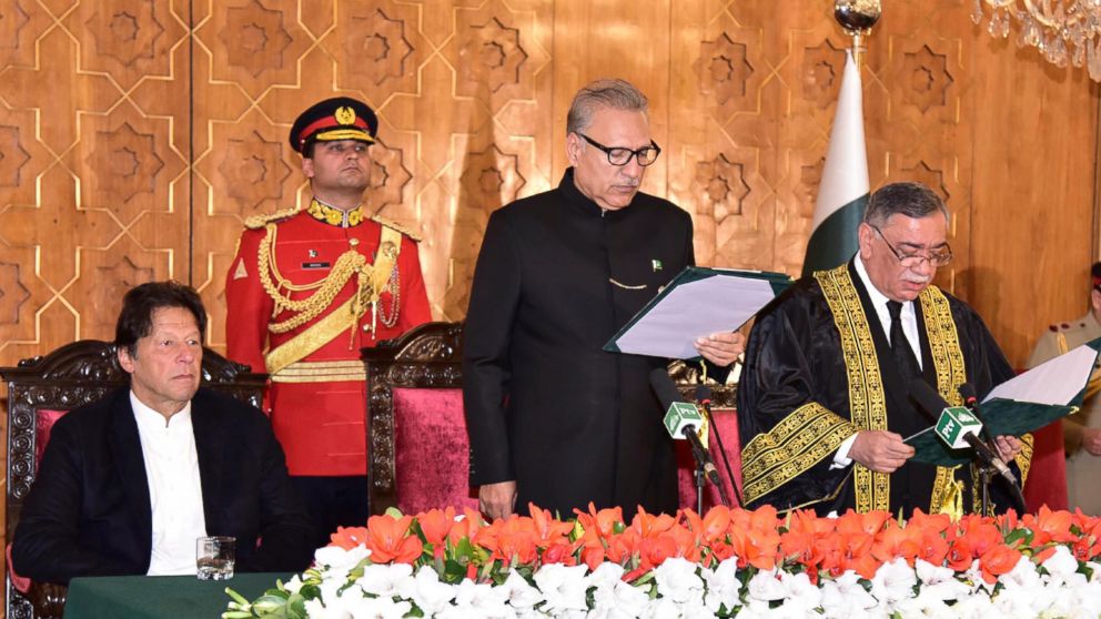 In this photo released by the Press Information Department of Pakistan, President of Pakistan Arif Alvi, center, administers the oath to Asif Saeed Khosa, right, as the country's new chief justice of the Supreme Court in Islamabad, Pakistan, Friday, 
