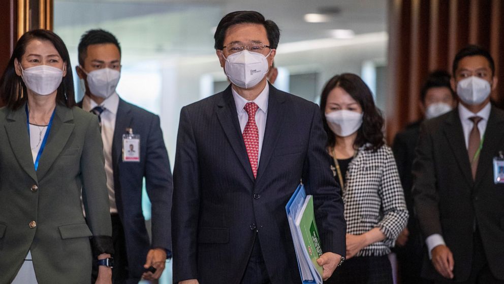 Hong Kong Chief Executive John Lee, center, enters the chamber of the Legislative Council in Hong Kong, Wednesday, Oct. 19, 2022. Hong Kong's leader on Wednesday unveiled a new visa scheme to woo global talent, as the city seeks to stem a brain drain