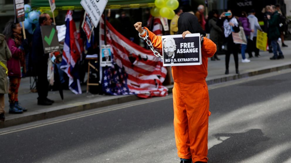 A demonstrator holds a banner outside the Old Bailey in London, Thursday, Oct. 1, 2020, as the Julian Assange extradition hearing to the US continues. (AP Photo/Kirsty Wigglesworth)