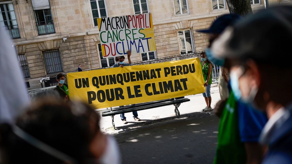 Climate activists hold a sign that reads "a five-year term lost for the climate" during a demonstration in Paris, Tuesday, July 20, 2021. France's parliament is holding a final vote Tuesday on a compromise climate bill that was meant to transform tra
