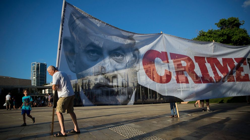 FILE - Israelis carry a banner showing Israeli Prime Minister Benjamin Netanyahu during a protest against the Israel Jewish nation bill, in Tel Aviv, Israel, July 30, 2018. Netanyahu is set to return to power, from where he could try to make his year