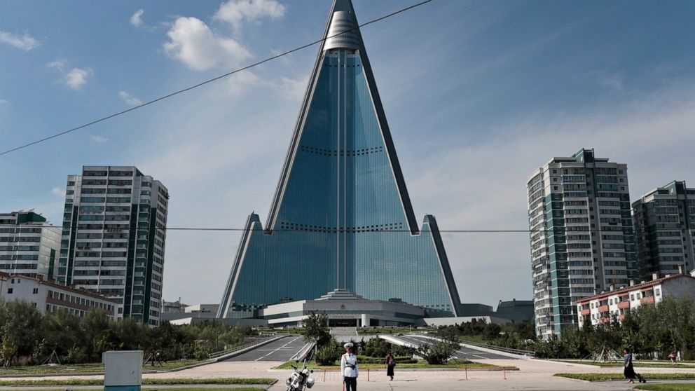 FILE - A traffic officer is dwarfed by the 105-story Ryugyong Hotel in Pyongyang, North Korea, Wednesday, Sept. 11, 2019. U.S. President Joe Biden met Monday, May 23, 2022, while visiting Japan with families of citizens abducted by North Korea decade