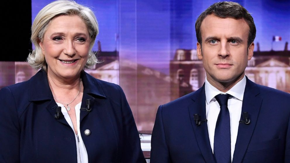 FILE- French presidential election candidate for the far-right Front National party, Marine Le Pen, left, and French presidential election candidate for the En Marche ! movement, Emmanuel Macron, pose prior to the start of a live broadcast face-to-fa
