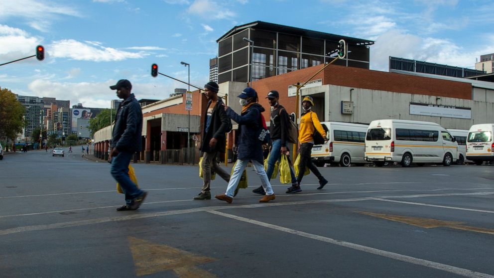 Pedestrians walks on the street in downtown Johannesburg, South Africa, Thursday, April 9, 2020. South Africa and more than half of Africa's 54 countries have imposed lockdowns, curfews, travel bans or other restrictions to try to contain the spread 