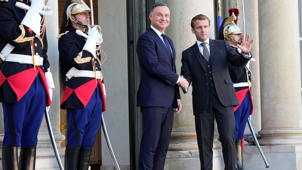 French President Emmanuel Macron, right, and Poland's President Andrzej Duda shake hands before a working lunch at the Elysee Palace Wednesday, Oct. 27, 2021 in Paris. The European Union's top court has ordered Poland to pay 1 million euros a day ($1