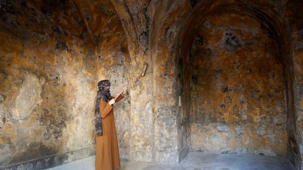 A female artist volunteer cleans a room of the long-abandoned 200-year-old al-Kamalaia school, in the old quarter of Gaza City, Sunday, Dec. 20, 2020. Less than 200 of these old houses are still partly or entirely standing, according to officials and