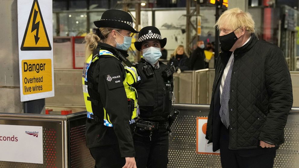 Britain's Prime Minister Boris Johnson meets British Transport Police officers at Liverpool Lime Street station, Liverpool, England, Monday Dec, 6, 2021, ahead of the publication of the government's 10-year drug strategy. (Christopher Furlong/Pool via AP)