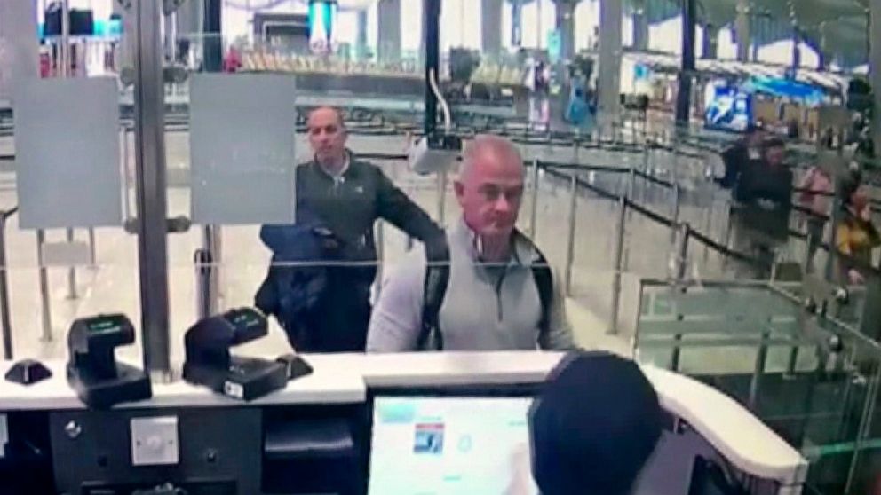 FILE— This Dec. 30, 2019 image from security camera video shows Michael L. Taylor, center, and George-Antoine Zayek at passport control at Istanbul Airport in Turkey. Americans Michael Taylor and his son Peter Taylor go on trial in Tokyo on Monday, J