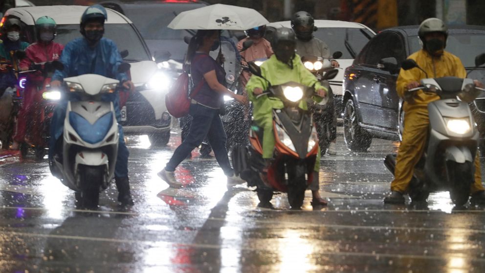 People walk in the rain ahead of the approaching Typhoon Muifa in Taipei, Taiwan, Monday, Sept. 12, 2022. (AP Photo/Chiang Ying-ying)