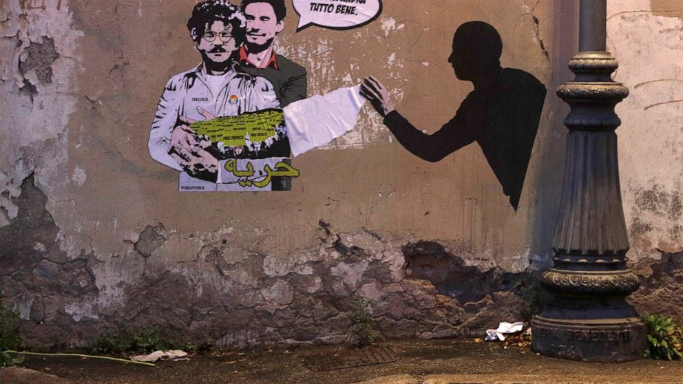 FILE - A mural depicts detained Egyptian human rights advocate and student at the University of Bologna in Italy, Patrick George Zaki, being hugged from behind by Italian researcher Giulio Regeni, who was murdered in Cairo in 2016, on a wall in Rome,