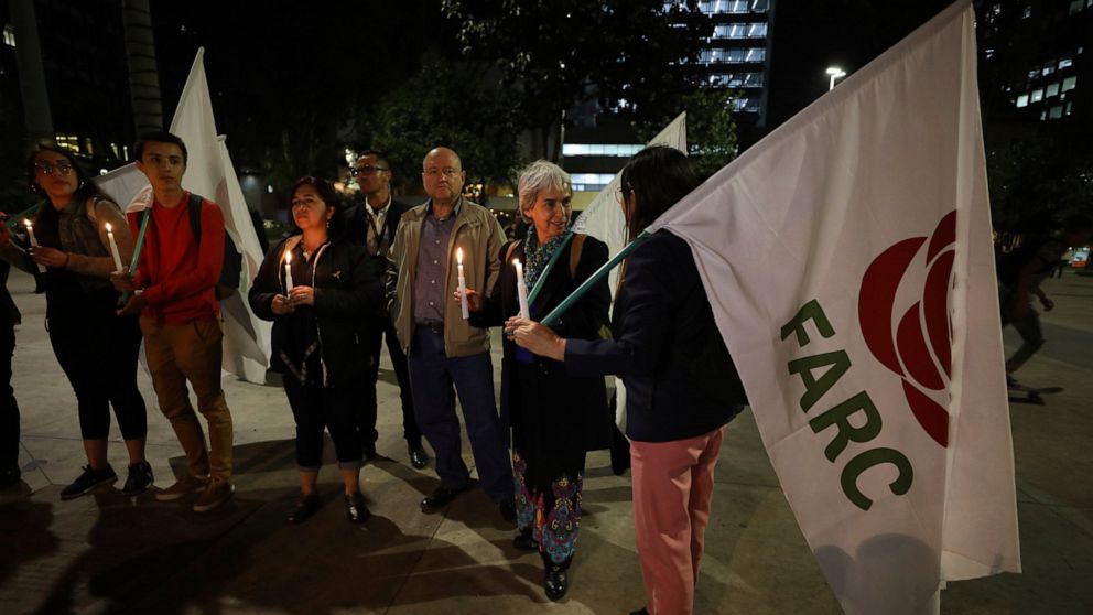 FILE - In this March 8, 2020 file photo, members of the Common Alternative Revolutionary Force, the political party formed after the disbanding of the Revolutionary Armed Forces of Colombia (FARC), hold a candlelight vigil for former rebels who have 