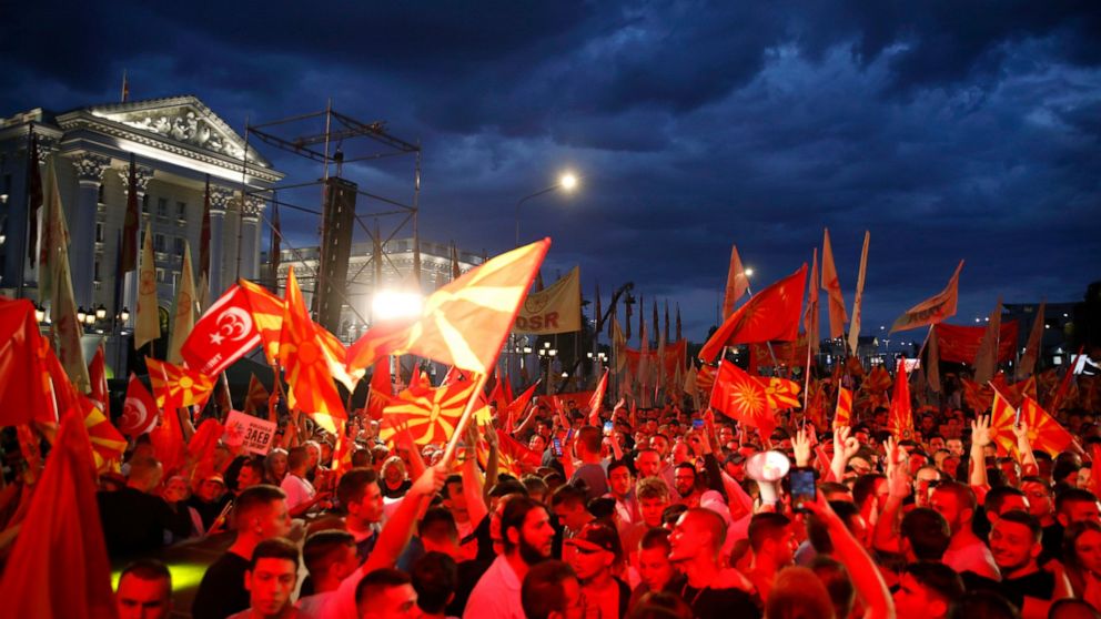Supporters of the opposition VMRO-DPMNE party wave party and national flags in front of the government building in Skopje, North Macedonia, on Saturday, June 18, 2022. Thousands of opposition supporters have gathered late on Saturday for anti-governm