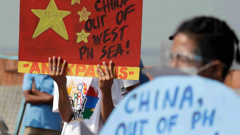 FILE - An activist holds a sign against a recently passed Chinese Coast Guard law during a rally in Manila, Philippines on Wednesday, Feb. 24, 2021. The Philippine government summoned the Chinese ambassador Monday, March 14, 2022, to protest what it 