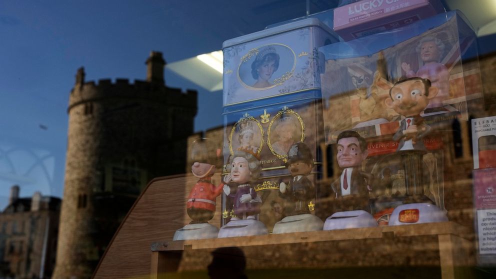 Souvenirs are displayed for sale in the window of a shop with a reflection of Windsor Castle, in Windsor, England, where Prince Andrew residence is nearby in the grounds of Windsor Great Park, Thursday, Jan. 13, 2022. A judge has — for now — refused 