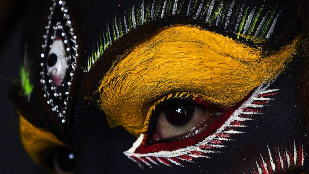 An Indian artist gets make up before a performance during a procession of "Bonalu" festival in Hyderabad, India, Monday, July 25, 2022. Bonalu is a month-long Hindu folk festival of the Telangana region dedicated to Kali, the Hindu goddess of destruc