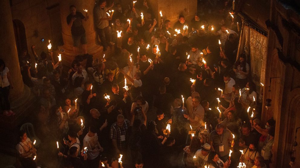 FILE - Christian pilgrims hold candles as they gather during the ceremony of the Holy Fire at Church of the Holy Sepulchre, where many Christians believe Jesus was crucified, buried and rose from the dead, in the Old City of Jerusalem on May 1, 2021.