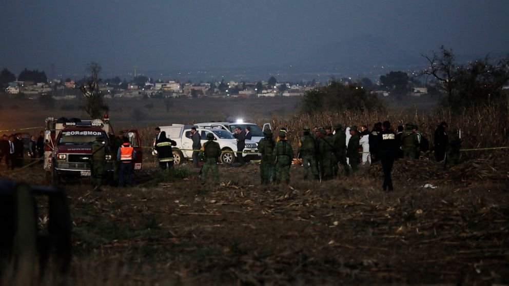 FILE - In this Dec. 24, 2018, file photo, emergency rescue personnel, the army and the police arrive work at the scene of a helicopter crash near Puebla City, Mexico. Four people have been arrested in connection with the crash that killed a central M