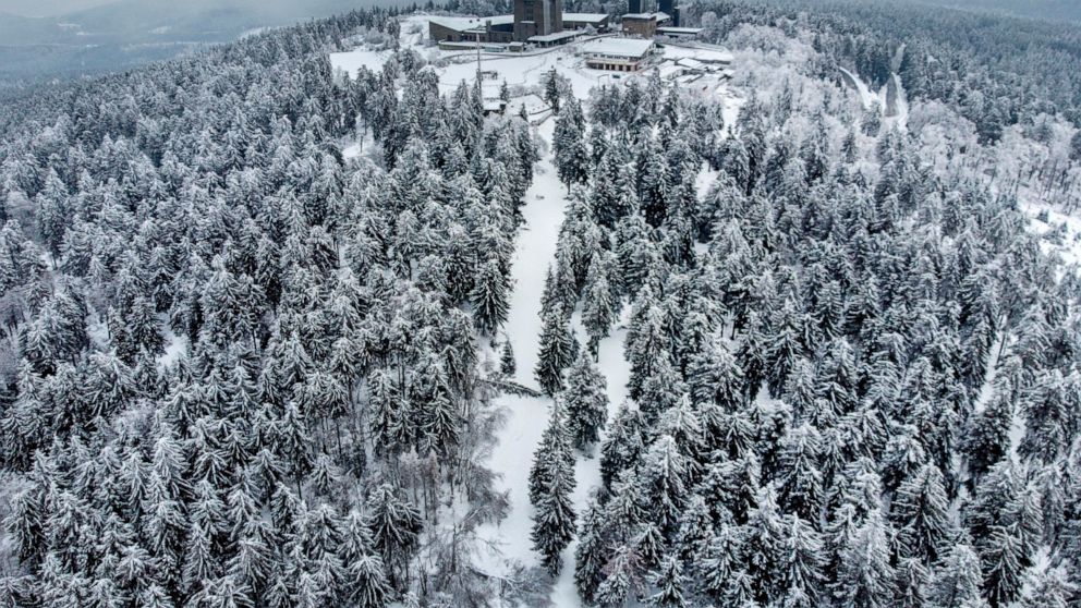 Trees are covered with ice rain, frozen fog and snow on top of the Feldberg mountain near Frankfurt, Germany, Tuesday, Feb. 9, 2021. Temperatures on top of the mountain were minus 14 degrees celsius (6.8 degrees in Fahrenheit). (AP Photo/Michael Probst)