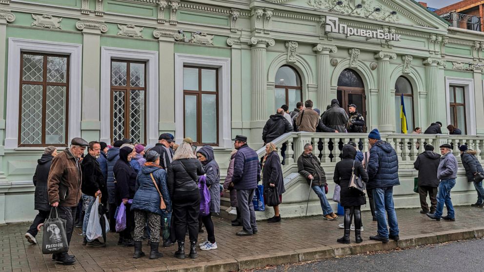 FILE - Residents queue at a bank branch in Kherson, southern Ukraine, Nov. 21, 2022. Even as Ukraine celebrates recent battlefield victories, its government faces a looming challenge on the financial front: how to pay the enormous cost of the war eff
