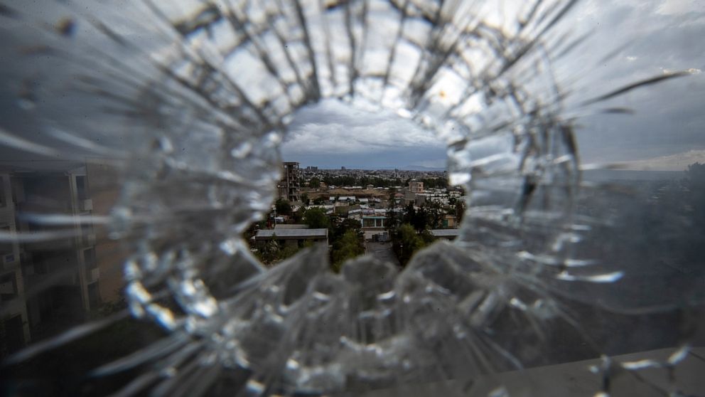 FILE - In this Thursday, May 6, 2021 file photo, the city of Mekele is seen through a bullet hole in a stairway window of the Ayder Referral Hospital, in the Tigray region of northern Ethiopia. Ethiopian military airstrikes have hit the capital of th