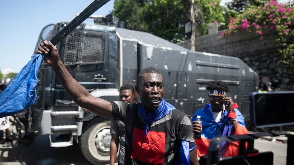 A man holds up a machete during a protest to demand that Haitian Prime Minister Ariel Henry step down and a call for a better quality of life, in Port-au-Prince, Haiti, Wednesday, Sept. 7, 2022. (AP Photo/Odelyn Joseph)